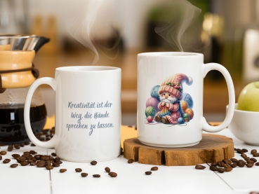 Tassen-Set mit kreativem Design: eine Tasse zeigt einen niedlichen Wichtel mit Garnknäueln, die andere Tasse trägt den Spruch 'Kreativität ist der Weg, die Hände sprechen zu lassen'. Perfekt für kreative Menschen und Handarbeitsliebhaber.